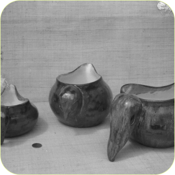 A black-and-white still life of small sculptural vessels.