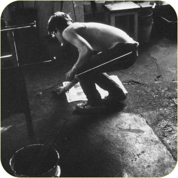 A grainy black-and-white photograph of a person working outdoors.